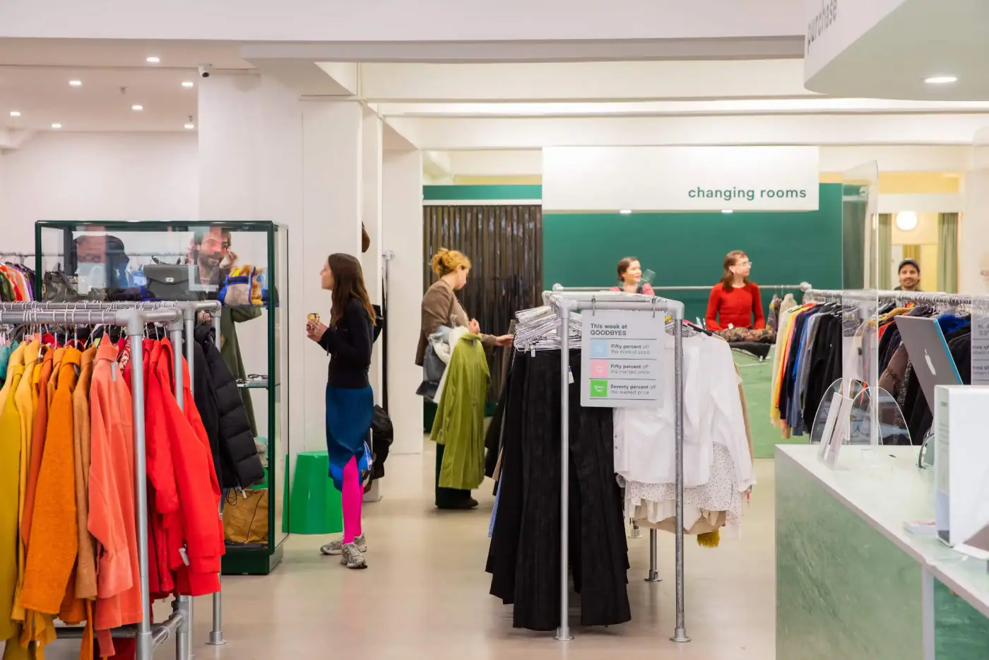 Inside Goodbyes' Brunswick store, racks of consigned clothing under green signage
