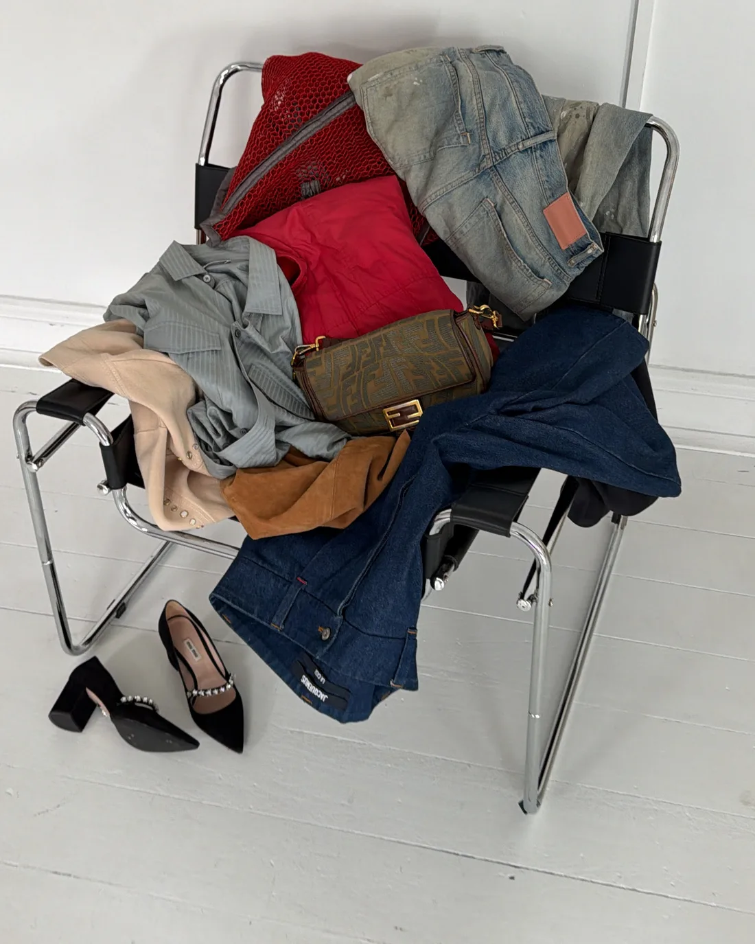 A pile of designer pieces on a chair, ready to consign